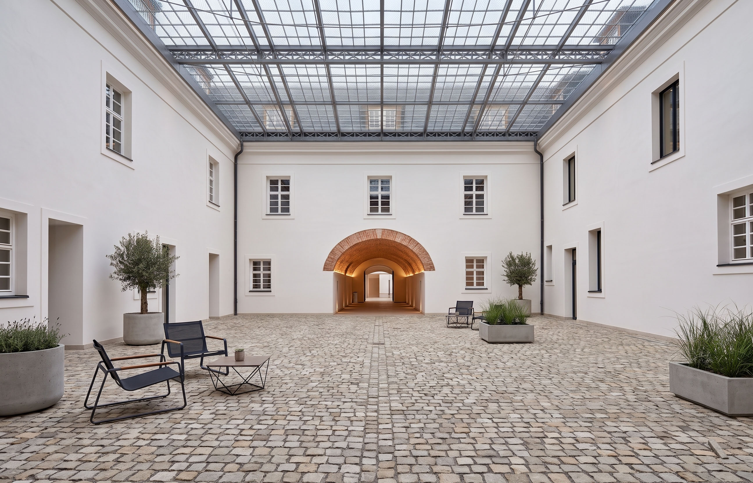 Kryté zámecké atrium s posezením a olivovníky