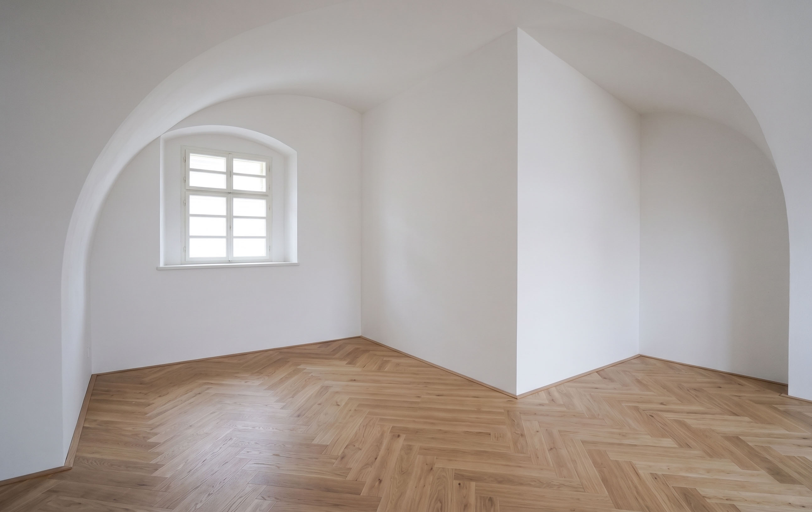 Světlý zámecký interiér se sochařsky tvarovanými klenbami