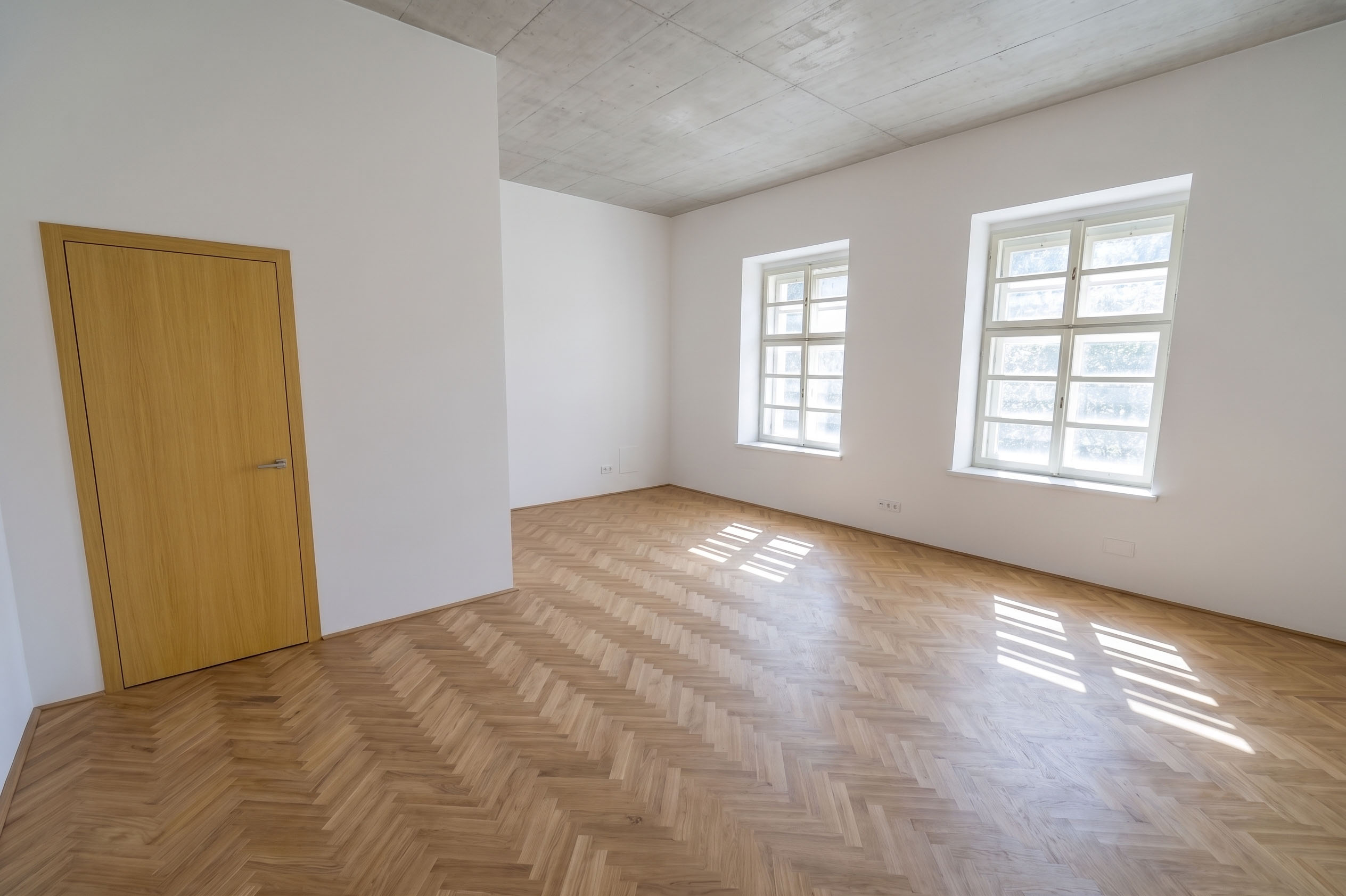 Obnovený pokoj s dvojicí zámeckých oken a parketami